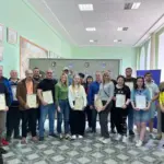 Група людей у військовій формі отримує сертифікати про завершення військового вишколу.