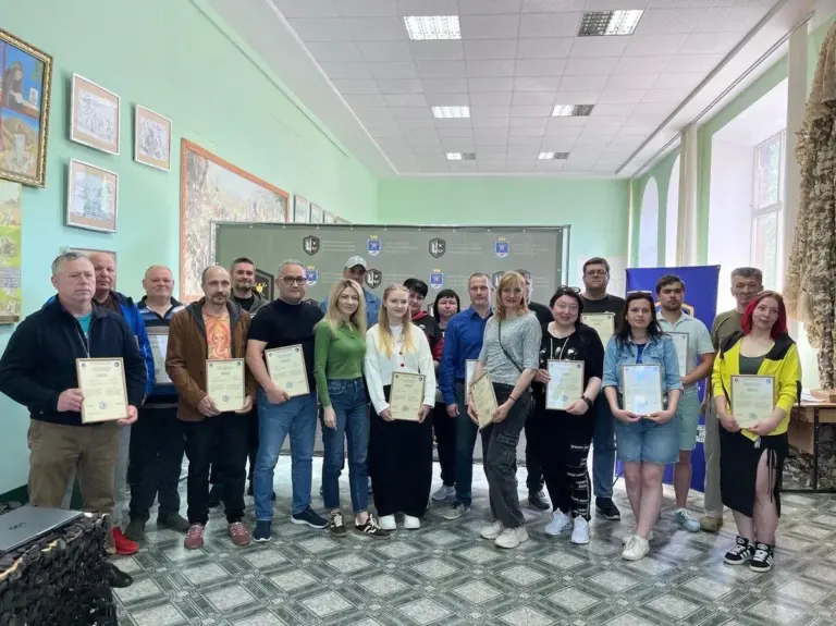 Група людей у військовій формі отримує сертифікати про завершення військового вишколу.