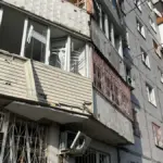 Пошкоджений будинок у Херсоні після російського обстрілу, видно уламки та сліди пожежі