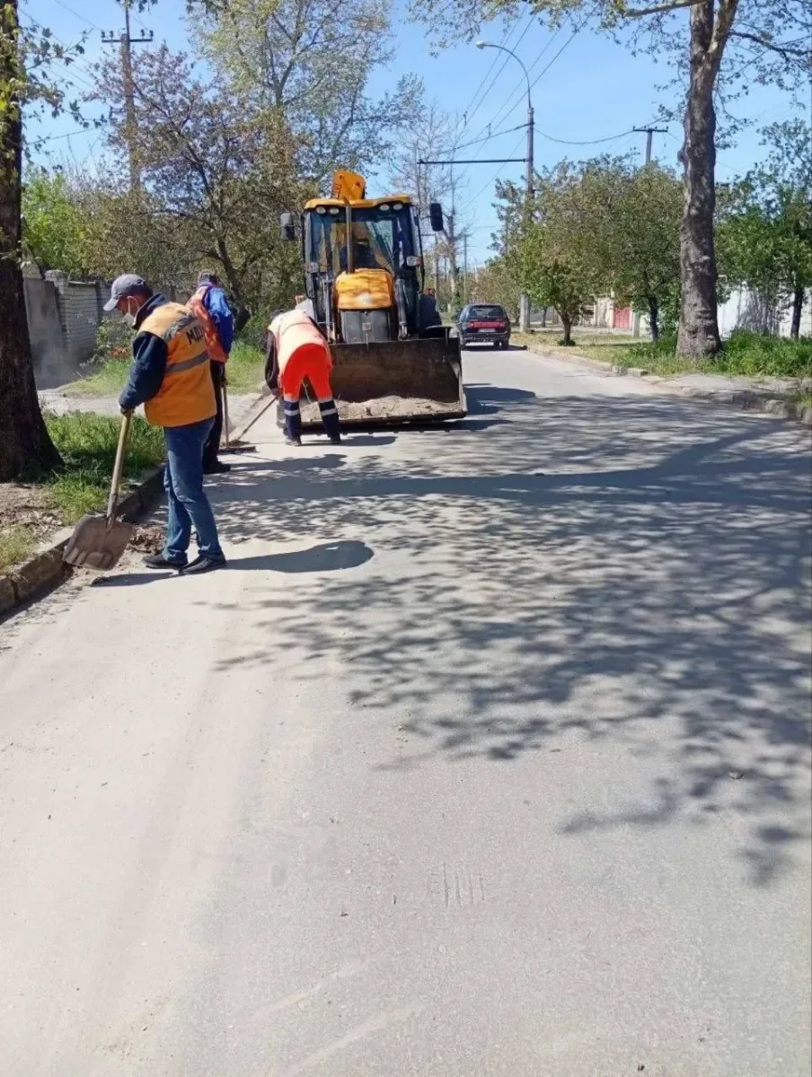 Працівники КП "Міське дорожнє управління" Херсона ремонтують дороги та закладають вікна мішками з піском для захисту. 3