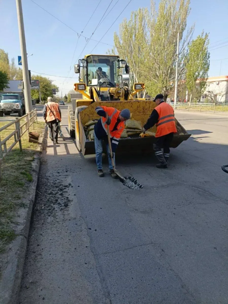 Працівники КП "Міське дорожнє управління" Херсона ремонтують дороги та закладають вікна мішками з піском для захисту. 8