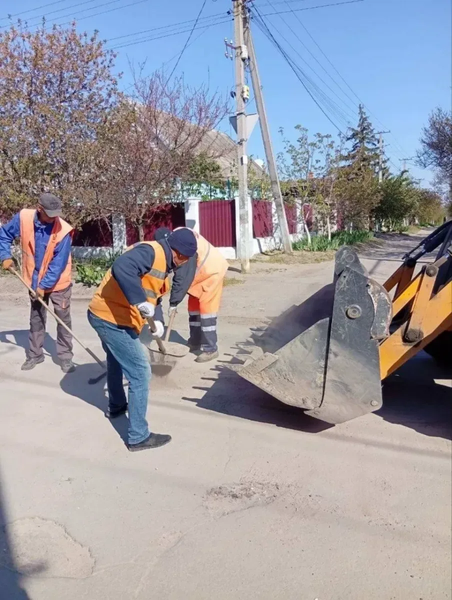 Працівники КП "Міське дорожнє управління" Херсона ремонтують дороги та закладають вікна мішками з піском для захисту. 9