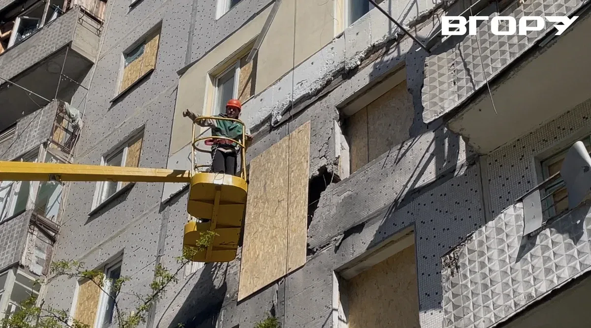 Працівники комунального підприємства «Парки Херсона» закривають вибиті вікна пошкодженої будівлі ОСБ-листами 1