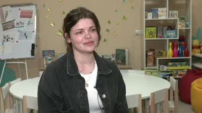 Жінка обіймає дитину на фоні зруйнованого Херсона, символізуючи материнство під час війни 3