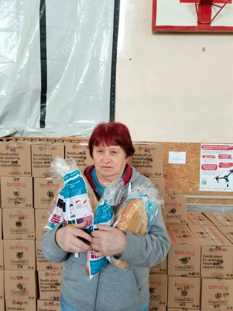 Волонтери роздають гуманітарну допомогу, включаючи хліб, продуктові набори та воду, жителям Херсонської громади. 2