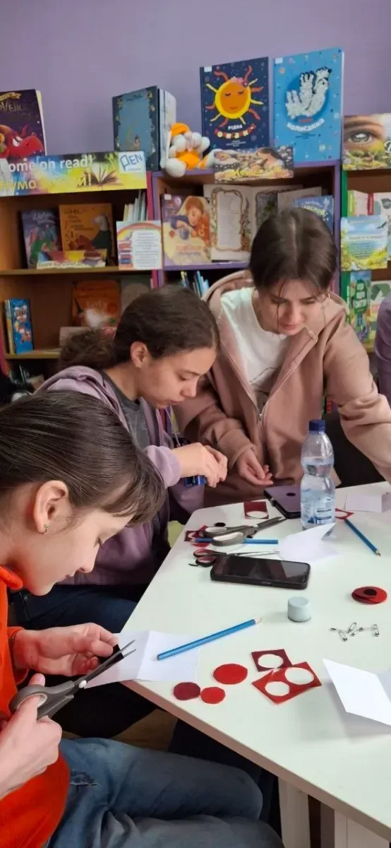 Діти створюють червоні маки на майстер-класі в Херсонській бібліотеці, вшановуючи пам'ять про полеглих у війні. 3