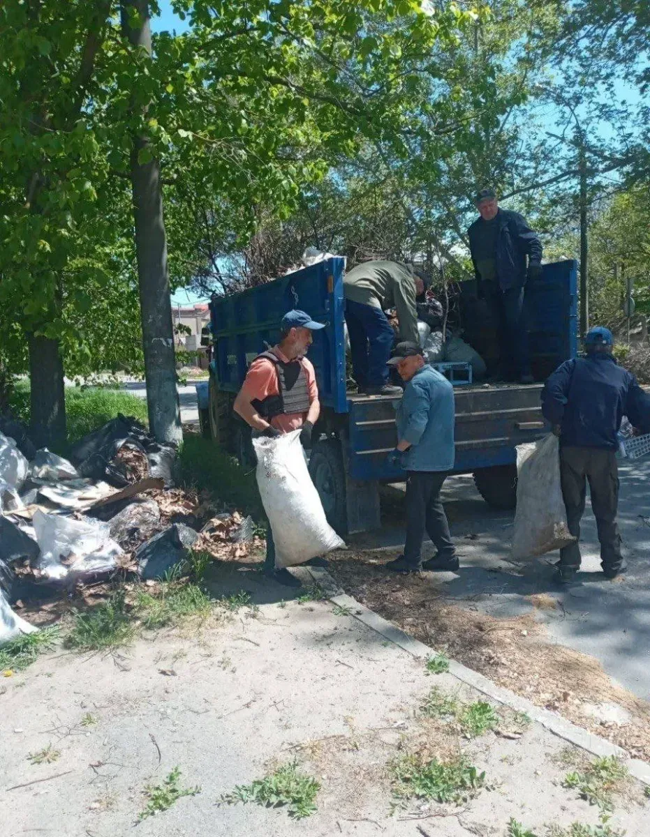 Сміттєві баки та великогабаритні бункери на вулиці Херсона, ілюструючи зміни у системі вивезення сміття через безпекову ситуацію. 2