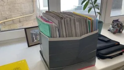 Жінка тримає документи, символізуючи труднощі оформлення спадщини на окупованій Херсонщині, де бракує доступу до майна. 4