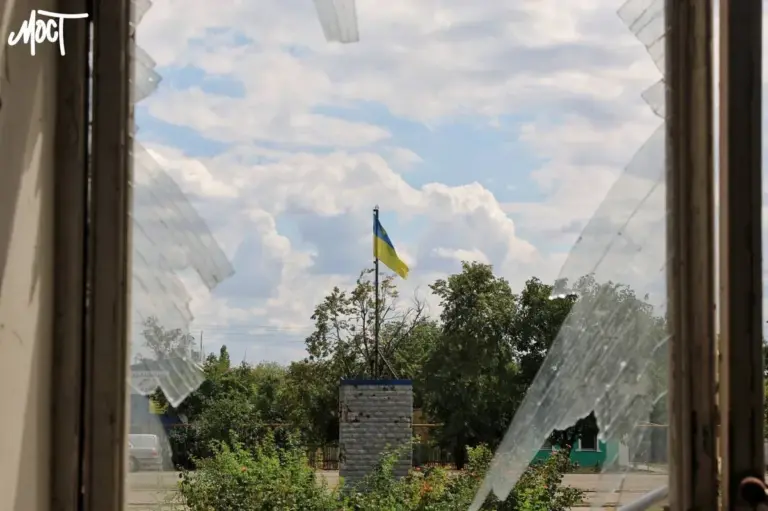 Хлопець стоїть на тлі прапора України, символізуючи повернення з окупації та безпеку