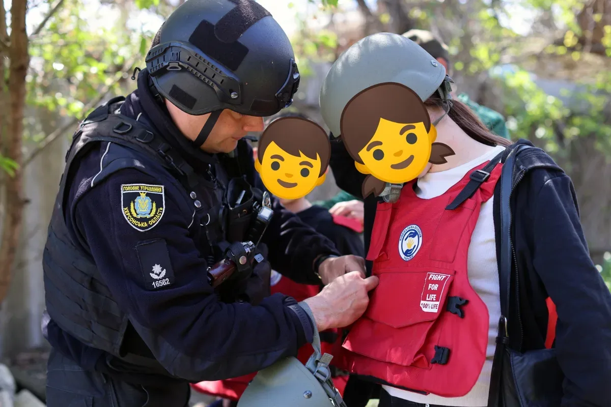 Поліцейські та волонтери евакуюють матір з дітьми з обстрілюваного передмістя Херсона броньованим автомобілем. 1