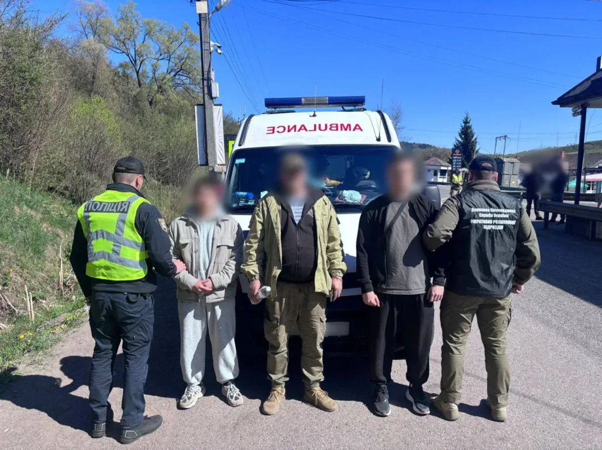 Автомобіль швидкої допомоги зупинено правоохоронцями на дорозі, біля нього стоять поліцейські та затриманий чоловік 5