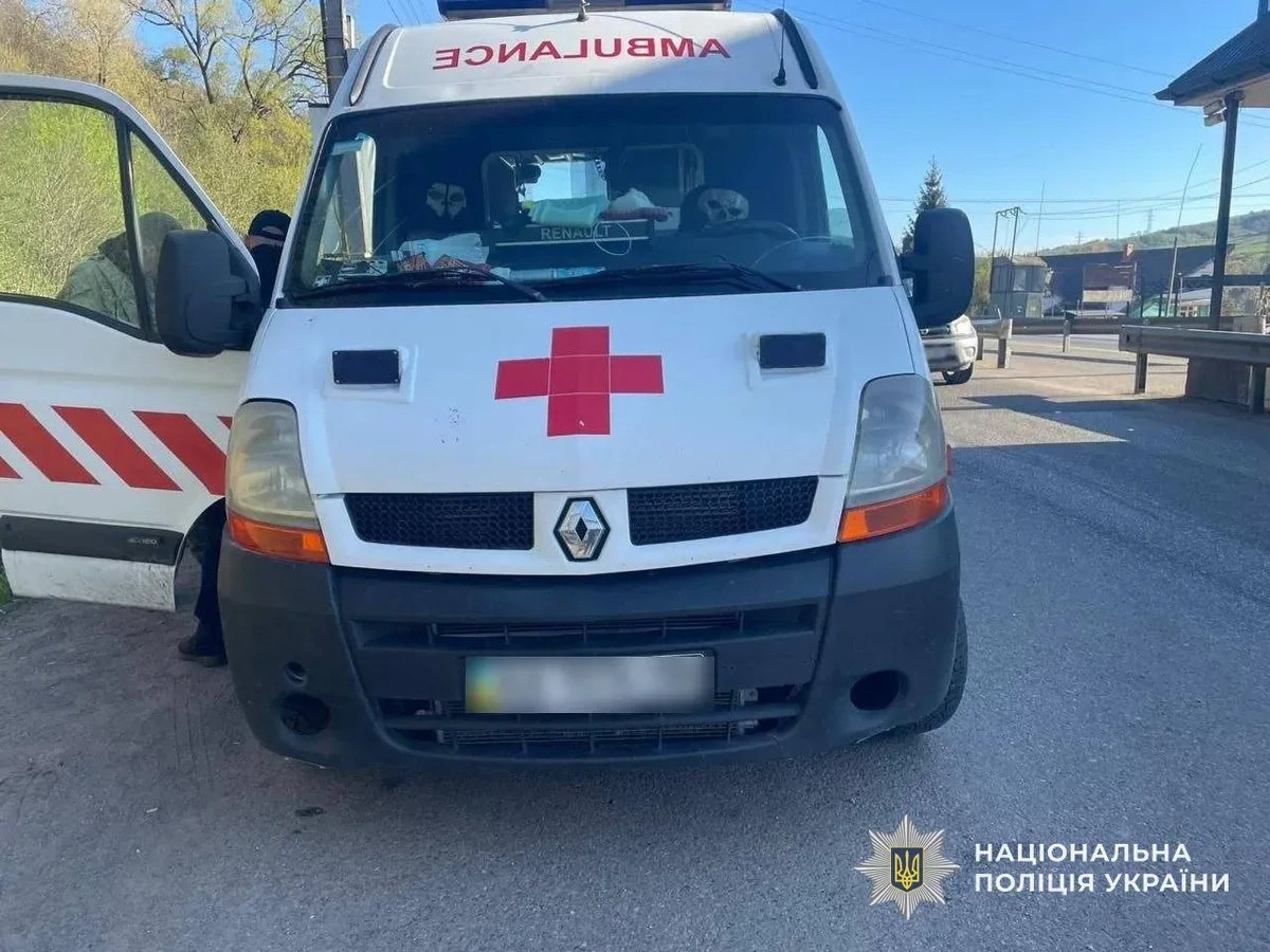 Автомобіль швидкої допомоги зупинено правоохоронцями на дорозі, біля нього стоять поліцейські та затриманий чоловік 1