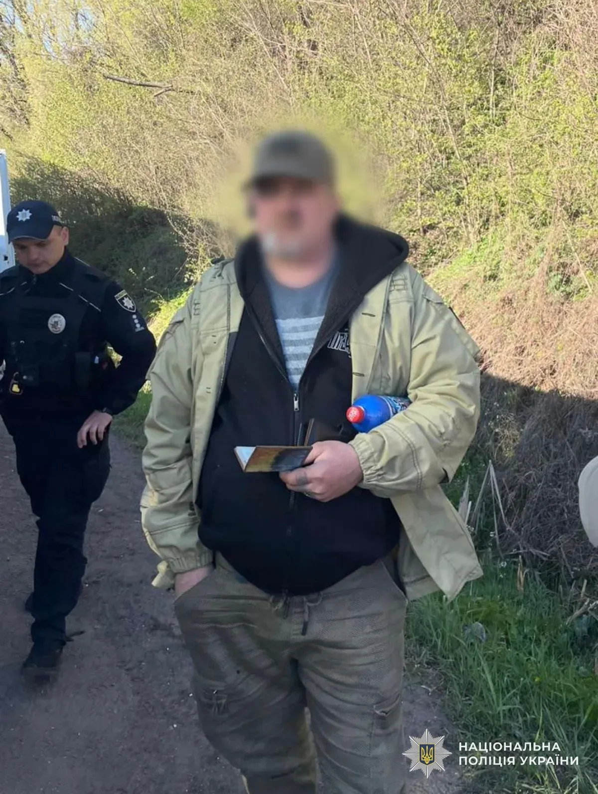 Автомобіль швидкої допомоги зупинено правоохоронцями на дорозі, біля нього стоять поліцейські та затриманий чоловік 4