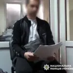 Поліцейський вилучає каністри з алкоголем у гаражі під час обшуку в Херсоні.