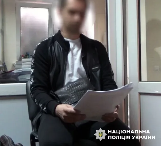 Поліцейський вилучає каністри з алкоголем у гаражі під час обшуку в Херсоні. 1