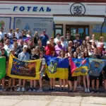 Група дітей та підлітків, учасників гри «Джура», у військовій формі, йдуть лісовою стежкою під час змагань.
