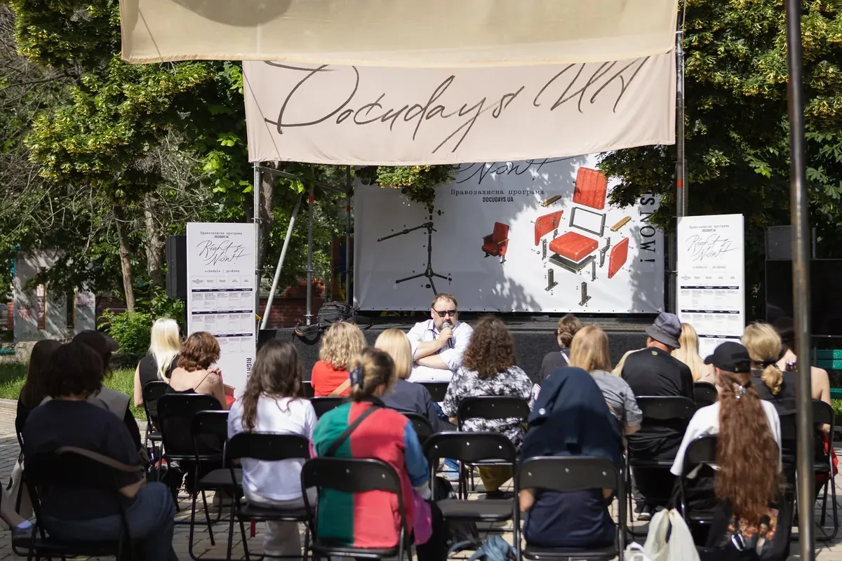 Логотип фестивалю Docudays UA та кінокамера на фоні міських декорацій. 4