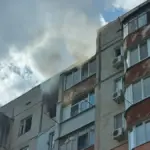 Рятувальники надають допомогу чоловіку після дронової атаки на багатоповерхівку в Херсоні.