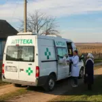 Мобільна аптека «на колесах» прибуває до села Херсонщини, біля мікроавтобуса стоять місцеві мешканці