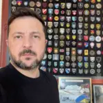 Володимир Зеленський звертається до українців на фоні українського прапора, говорячи про війну