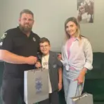 Помічник начальника ГУНП з ветеранської політики вручає подарунки дітям загиблих поліцейських у Херсоні.