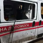 Пошкоджена автівка швидкої допомоги після атаки російського дрона у Херсоні, видно вибите скло та пробиті двері