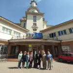 Група людей на екскурсії в Івано-Франківську, краєзнавиця розповідає про історію міста