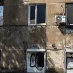 Зруйнований житловий будинок у Херсоні, на тлі якого виплачуються компенсації