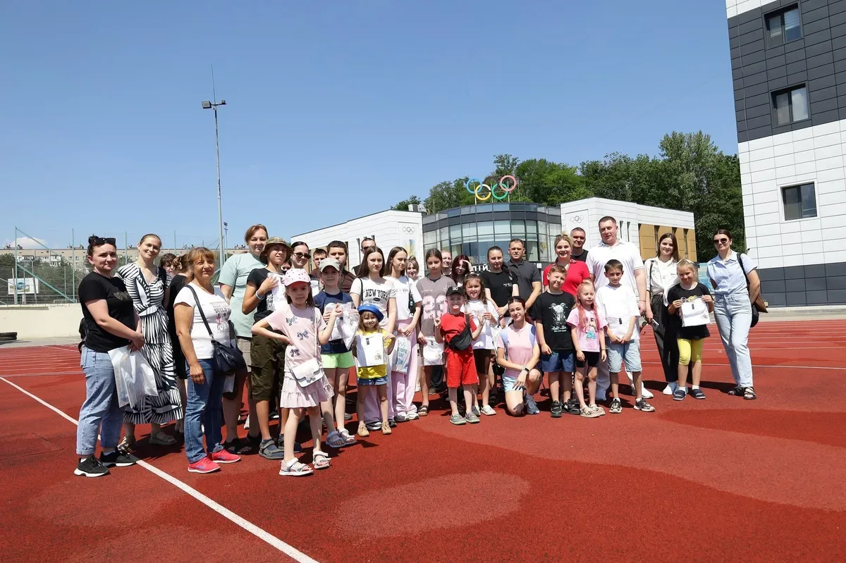 Діти та підлітки з Херсона беруть участь у спортивних змаганнях на стадіоні в Дніпрі, поряд стоять дорослі 7