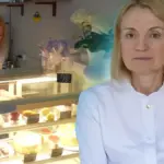 Тетяна Насонова у своїй кав'ярні в Херсоні, за прилавком, посміхається, навколо випічка. 5