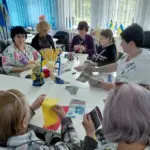 Жінки-переселенки з Херсонщини створюють ляльки-мотанки під час майстер-класу у Львові.