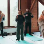 Людина виконує дихальні вправи, сидячи на підлозі, що символізує тілесні практики та турботу про ментальне здоров'я.
