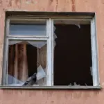 Російський паспорт лежить на паперах, що символізують відібране житло та окупаційні схеми