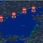 Знак, що забороняє рух транспорту на трасі, на фоні якої видно військову техніку