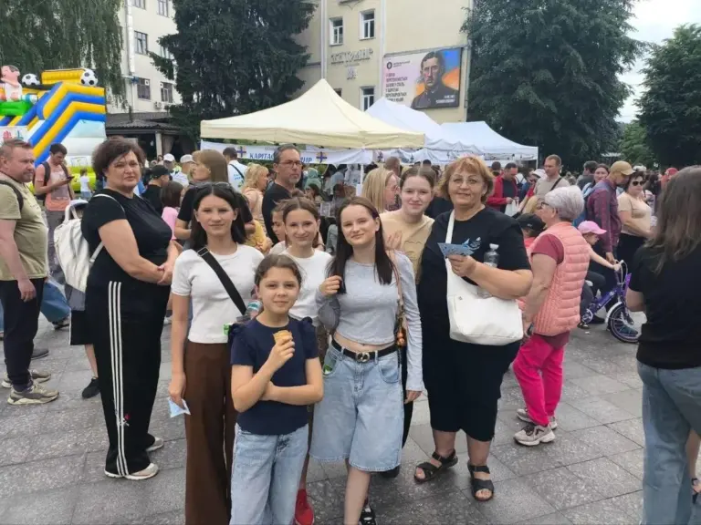 Діти-переселенці з Херсона радіють виграшу планшета на благодійній лотереї у Житомирі.