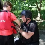 Поліцейські та волонтери евакуюють жінку з дитиною та домашніми тваринами з обстрілюваного району Херсона.