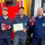 Співробітники Херсонського водоканалу отримують нагороди за мужність і професіоналізм біля стенду підприємства.