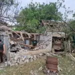 Пошкоджений будинок у Херсоні після російського авіаудару, видно вибиті вікна та зруйнований дах