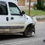 Пошкоджений автомобіль після атаки російського дрона у Херсоні, поруч медики надають допомогу постраждалим.
