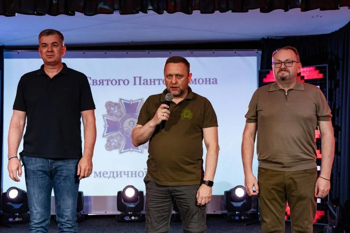 Група медиків Херсонщини, що стоять на сцені під час церемонії нагородження, на фоні банера конкурсу 5
