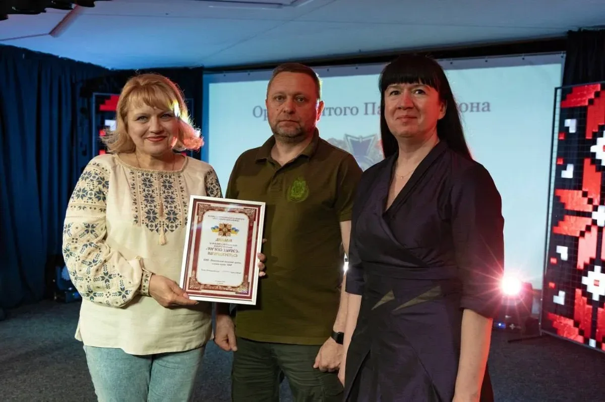 Група медиків Херсонщини, що стоять на сцені під час церемонії нагородження, на фоні банера конкурсу 7