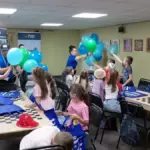 Діти слухають інструктаж з мінної безпеки, отримують ліфлети та розмальовки від фахівців.