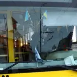 Тролейбус у Херсоні, що стоїть на зупинці, з оголошенням про тимчасову зупинку руху
