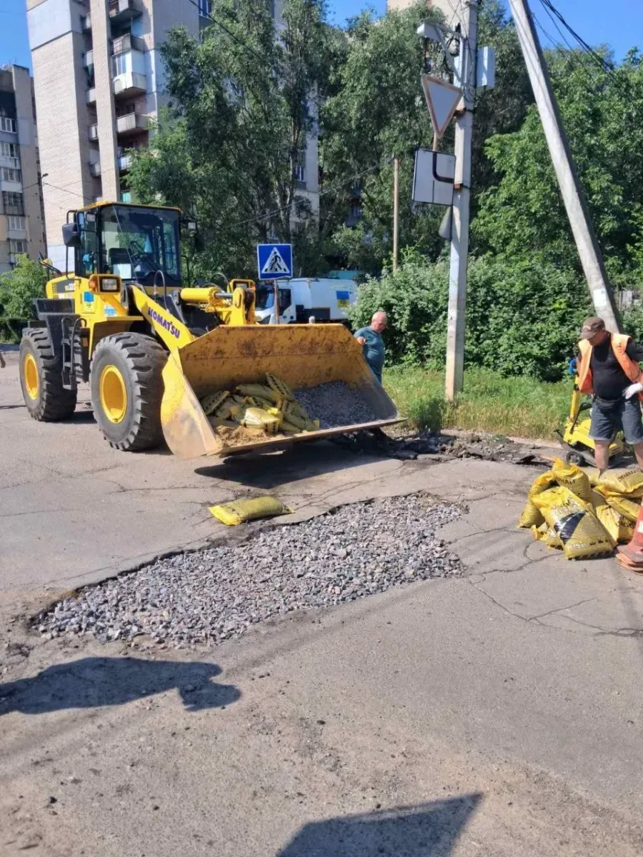 Працівники комунальної служби проводять ямковий ремонт дороги в Херсоні, закладаючи вибоїни. 1
