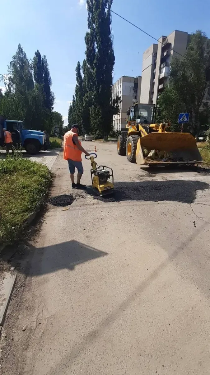 Працівники комунальної служби проводять ямковий ремонт дороги в Херсоні, закладаючи вибоїни. 9