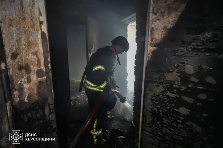 Рятувальники ДСНС працюють на місці пожежі в багатоповерховому будинку в Херсоні після влучання дрона