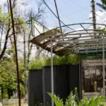 Пошкоджена зупинка громадського транспорту у Херсоні після атаки російського дрона, з пораненим чоловіком.