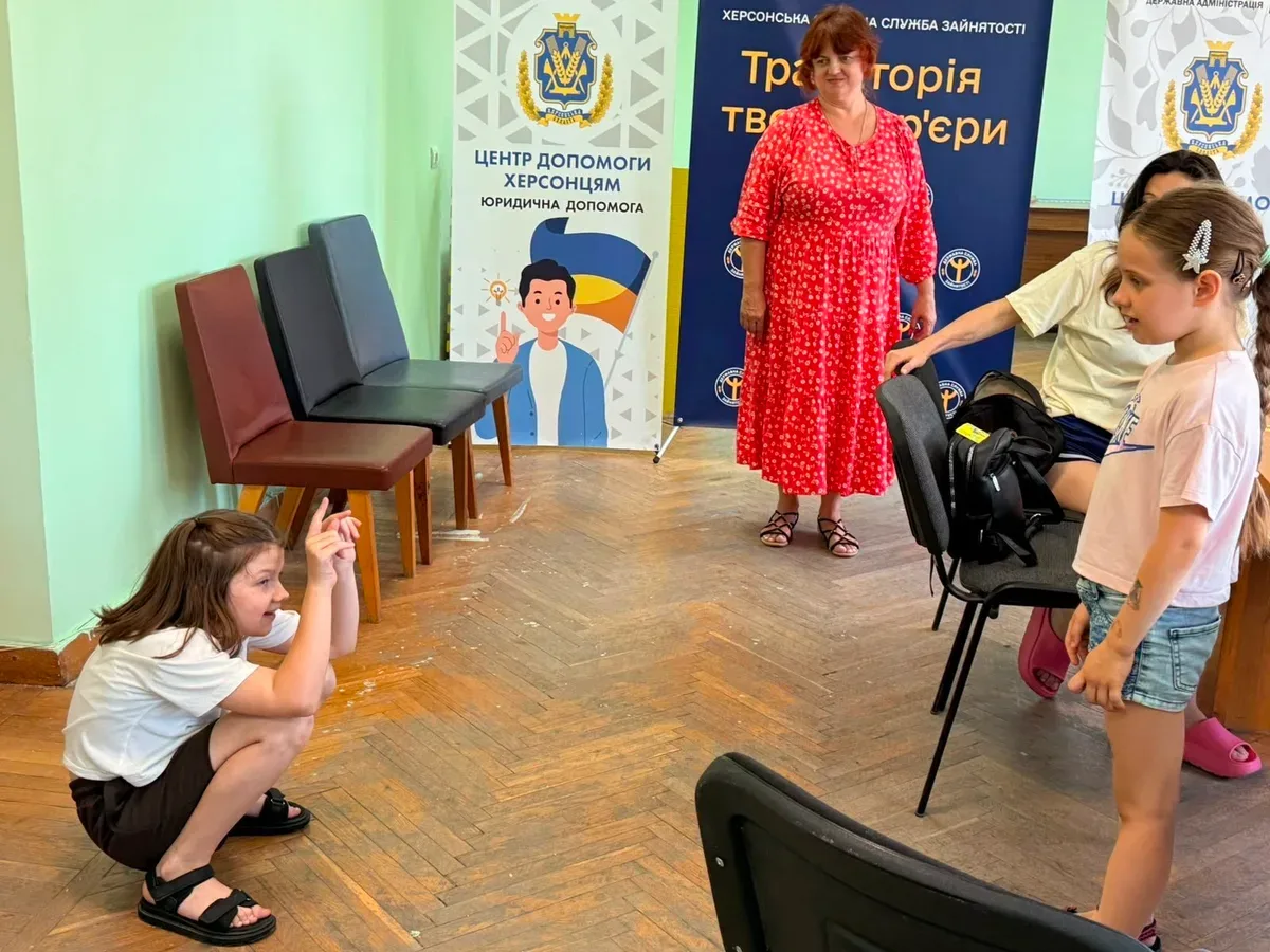 Діти та дорослі грають у «Крокодила» у Вінниці, показуючи слова жестами, сміються та спілкуються. 1