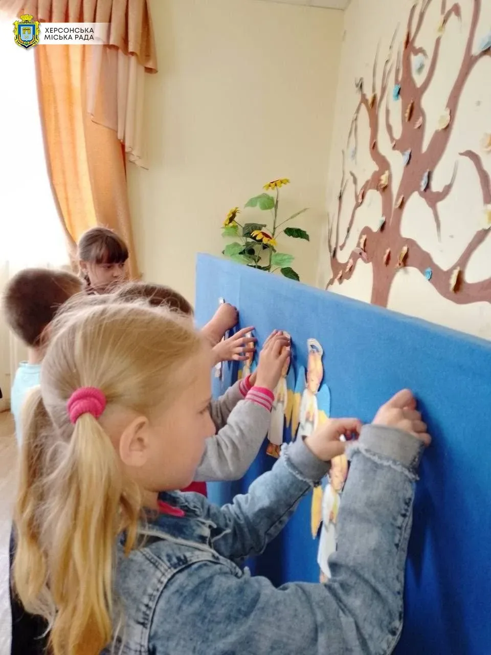 Діти розвішують паперових янголів у Будинку культури селища Петрівка на Херсонщині на згадку про загиблих дітей 3