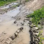 Символічне зображення крану з малою кількістю води на фоні зруйнованої інфраструктури в Херсонській області